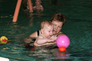 Kind watergewenning met bal in het water