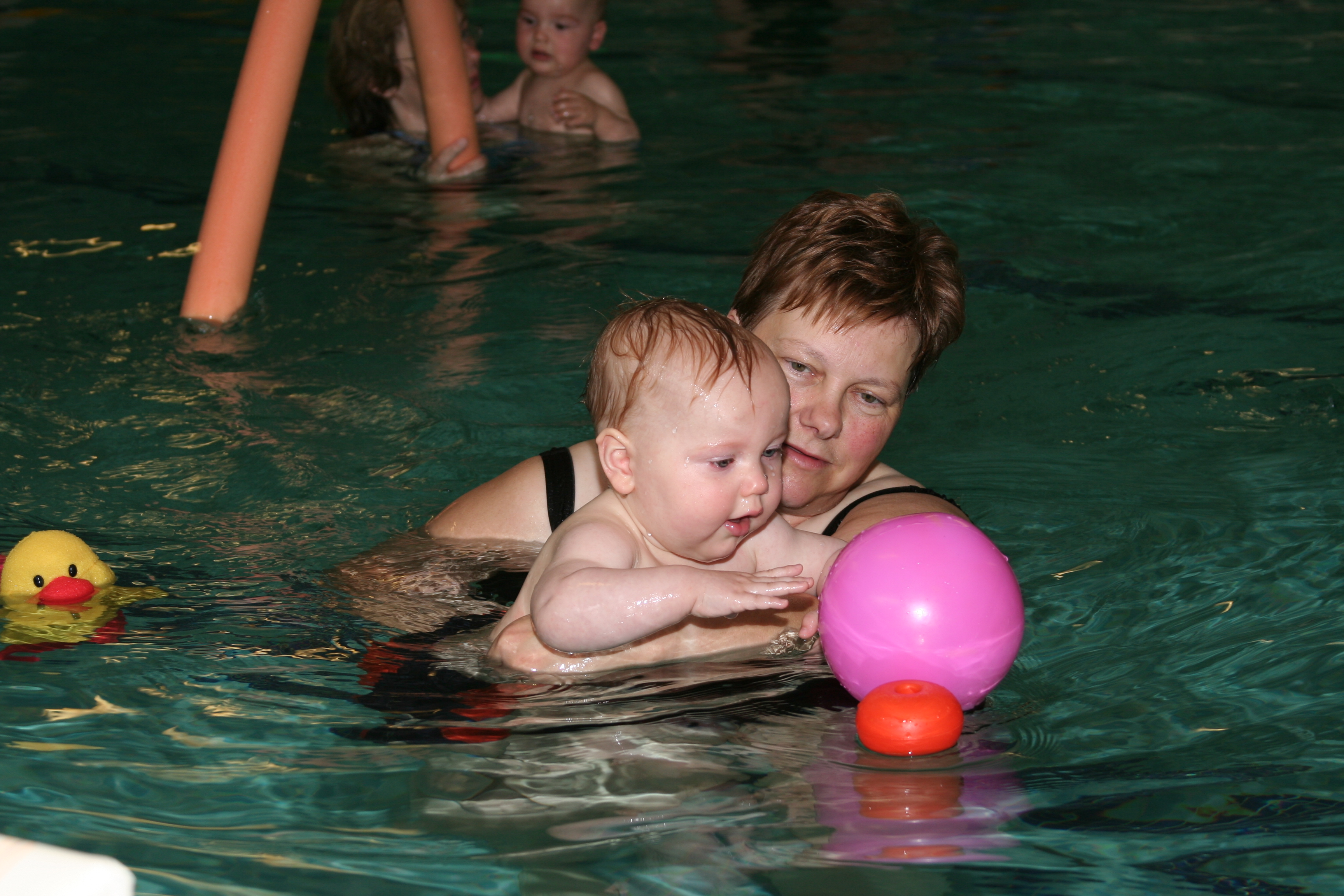 Kind watergewenning met bal in het water